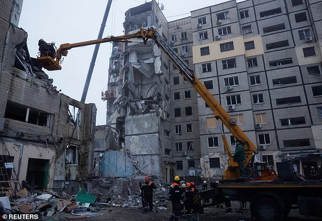 Emergency personnel work at the site where an apartment block was badly damaged by a Russian missile strike in Dnipro on Monday.