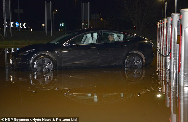 After plugging in his car, he climbed into the back seat of the Tesla and calmly waited for the charge to trickle into the batteries