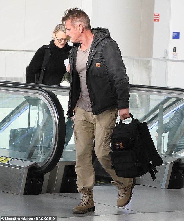 His Style Profile: Sean wore a modern outfit featuring a deep beige T-shirt under a dark gray zip-up hooded jacket, khaki pants and beige sneakers while carrying a backpack.