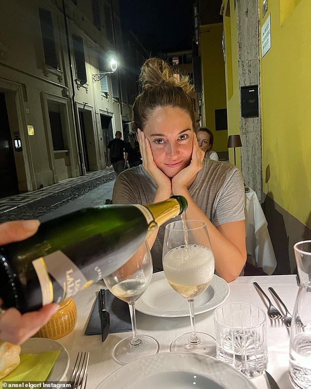 Romantic date night?  Shailene cupped her hands as a man, presumably Ansel, filled her wineglass.