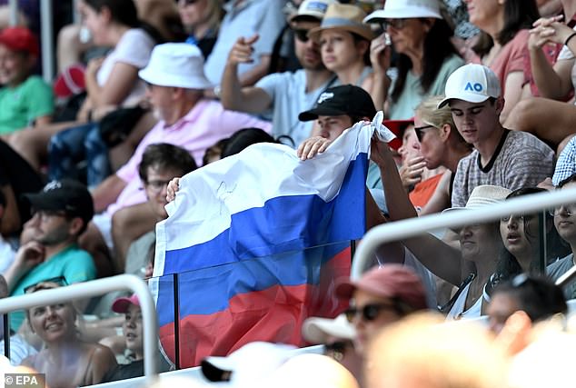 Spectators display a Russian flag during the first round singles match between Russia's Andrey Rublev and Dominic Them, despite Tennis Australia banning the emblem earlier that day after a complaint from the Ukrainian ambassador.