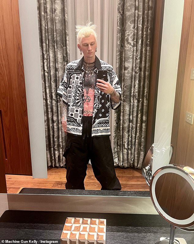 New Look: In addition to the metallic outfit, Machine Gun Kelly also donned a pair of black baggy pants along with a black and white print unbuttoned shirt.