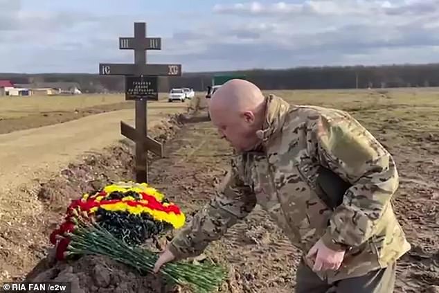 Pictured: Wagner's warlord Yevgeny Prigozhin lays flowers at the cemetery which houses more than 120 graves of fallen Russian soldiers, killed fighting for Vladimir Putin in Ukraine.