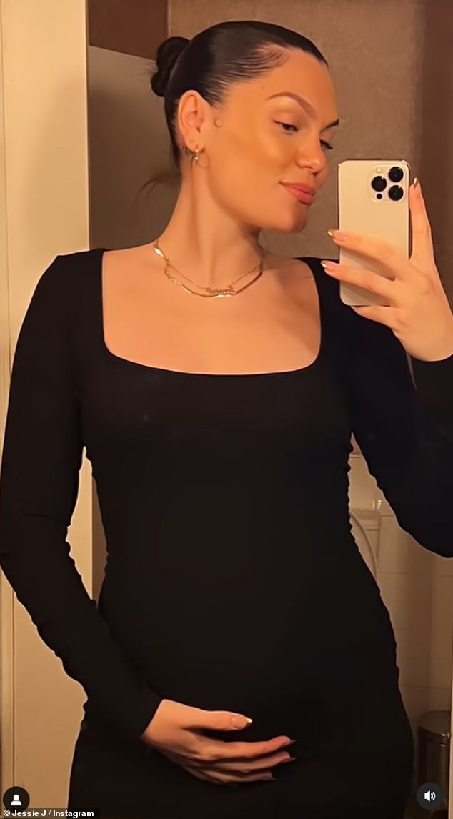 Mom-to-be: The singer, 34, cradled her blossoming baby bump in a black bodycon dress while taking a cheeky selfie in the bathroom