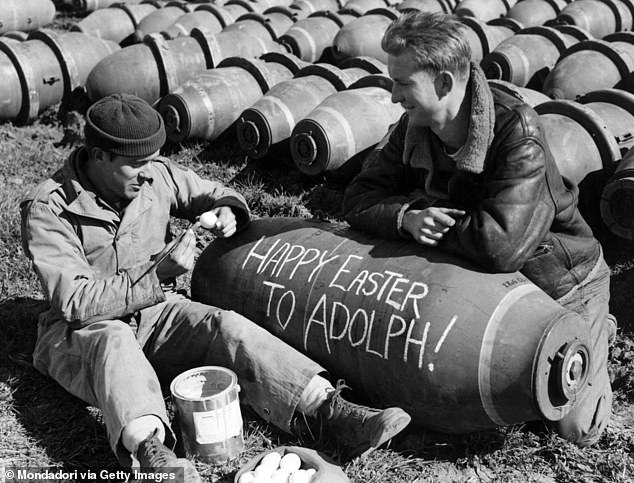 Two U.S. soldiers writing Easter greetings to Hitler on a bomb in southern Italy, March 1944