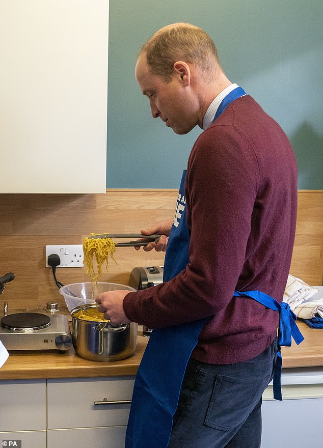 Prince William is photographed serving a pasta dish under the direction of chef Kevin Muhammad in the Together as One kitchen.