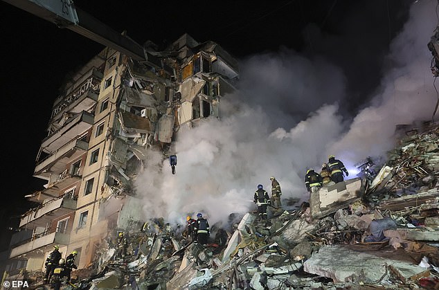 A rescue team works through the rubble of a shell-damaged residential building in Dnipro, southeastern Ukraine, on January 14, 2023.