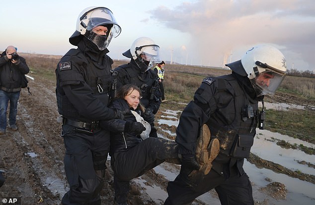 Police officers lead Swedish climate activist Greta Thunberg away from the edge of the Garzweiler II open-cast lignite mine during protests today.