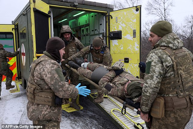 Ukrainian army medics evacuate a wounded soldier on a road not far from Soledar, Donetsk region, on January 14, 2023.