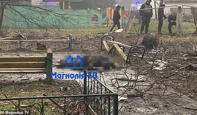 Pictured: A body is seen in the middle of a children's playground on the outskirts of the Ukrainian capital on Wednesday.