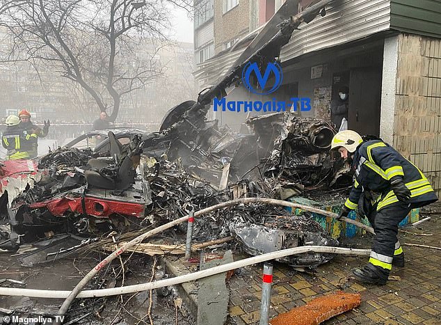 Emergency workers are seen at the scene after a plane crashed into a building near Kyiv.