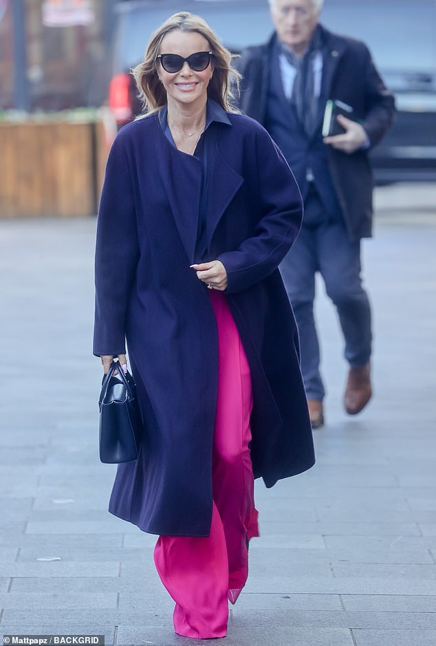 All smiles: Amanda looked typically in good spirits as she paraded her things across the pavement.