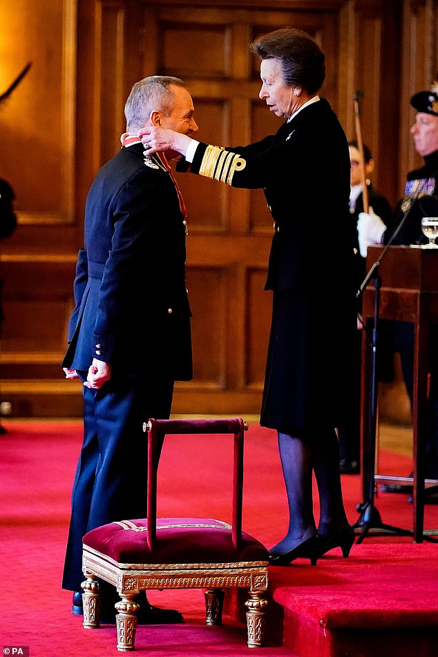 Anne places the honor around the neck of Sir Iain Livingstone during the investiture ceremony in Edinburgh on Wednesday.