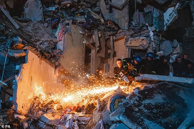 Pictured: Ukrainian rescuers search the rubble for survivors after a Russian missile hit an apartment block in Dnipro, killing at least 45 people, on Saturday.