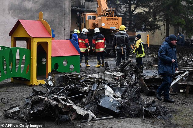 Firefighters work near the site where a helicopter crashed near a kindergarten in Brovary, on the outskirts of the capital Kyiv, killing sixteen people, including two children and Ukraine's Interior Minister, on January 18. of 2023.