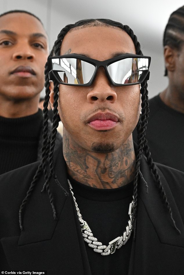 On trend: The rapper hid his eyes behind a pair of futuristic-looking sunglasses while his dark hair was in neat braids