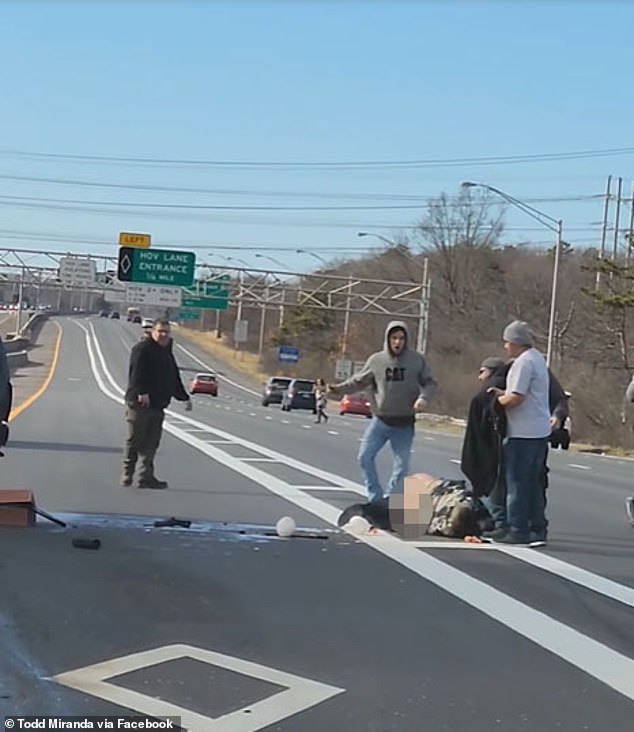 The men helped the woman, putting out the fire on her clothing and blocking traffic.