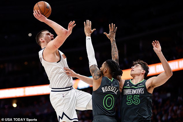 Nikola Jokic shoots the ball under pressure from D'Angelo Russell and center Luka Garza