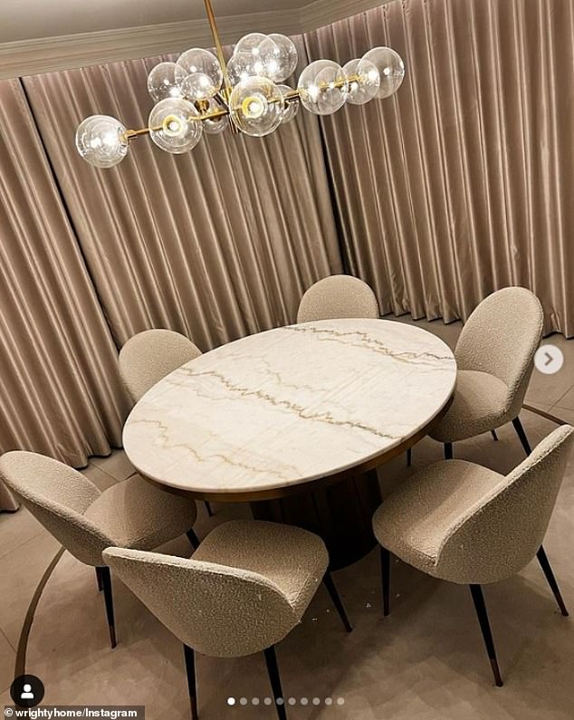 Classy: Captured the modern dining room, complete with a round marble table and comfortable beige shearling chairs.  Above the table was an extravagant lamp made of gold tubes and delicate glass spheres.