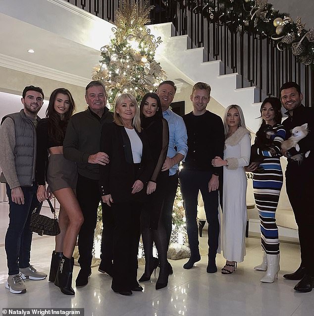 Happy: Mark and Michelle (far right) snuggled up as they hosted an early family Christmas celebration on Saturday at their £3.5m Essex mansion.