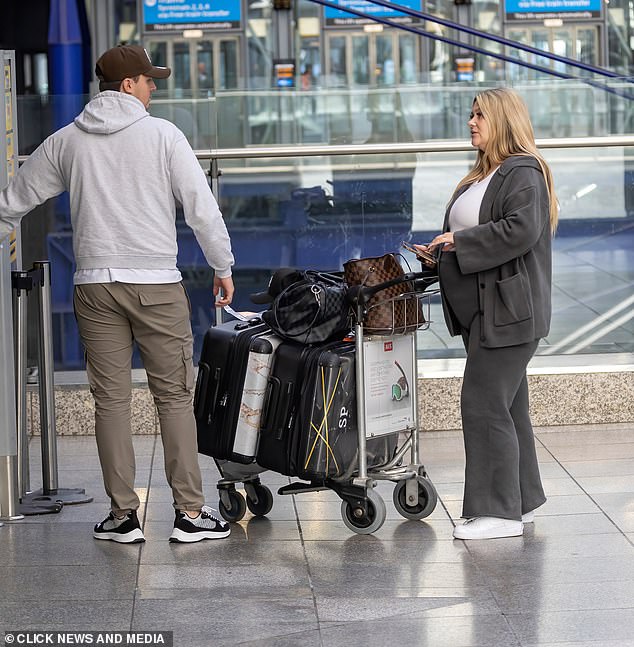 Lots of luggage: She pushed her three suitcases onto a trolley, with two leather Louis Vuitton bags hanging on top.