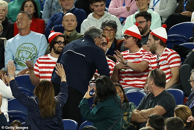 Security officer talks to four fans wearing Where's Wally costumes at Rod Laver Arena