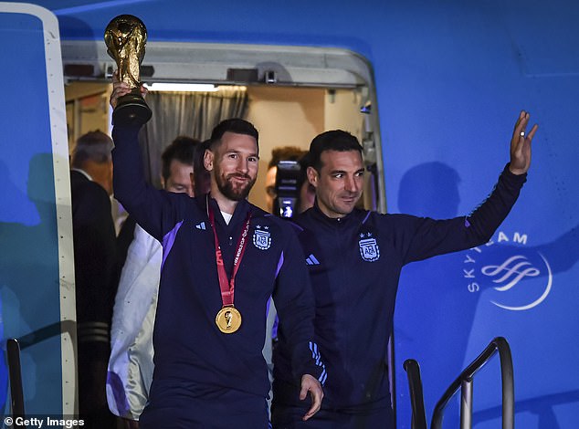 Messi holds the World Cup trophy alongside Scaloni as the team arrives in Buenos Aires