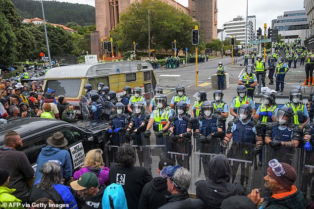 Police hold riot shields as demonstrators against Covid-19 vaccine mandates and restrictions gather outside of the New Zealand Parliament grounds in Wellington on March 2, 2022