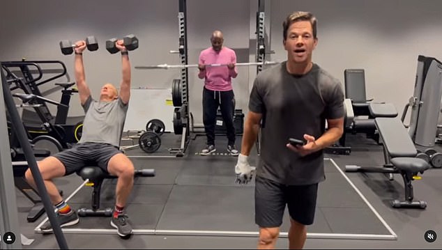 Mark Wahlberg is shown in a video from a gym above, talking through a work out