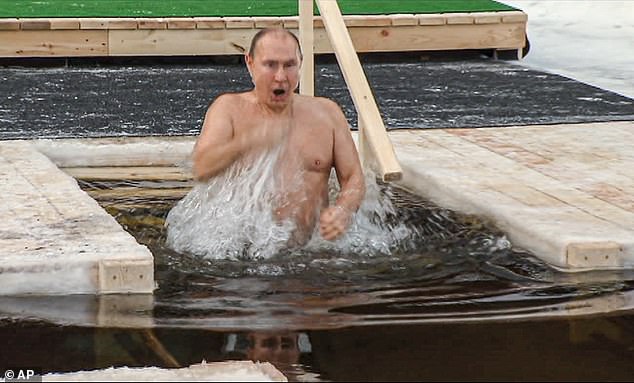 Russian President Vladimir Putin crosses himself as he bathes in ice-cold water during a traditional Epiphany celebration in Moscow, January 2019.