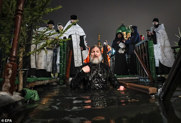 A Russian Orthodox priest plunges into ice cold water in a pond during celebrations for the Orthodox holiday of Epiphany, in Moscow, Russia, on January 18, 2023.