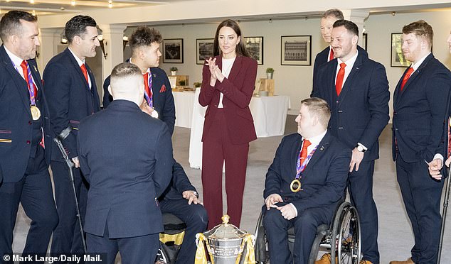 Kate looked effortlessly chic in the tailored burgundy suit which she teamed with a white sweater and gold jewelry.