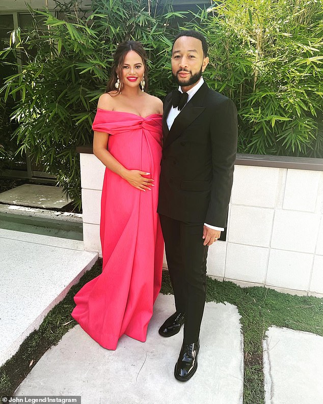 Glammed up: The mom-to-be looked stunning in a hot pink dress as she posed next to her handsome husband