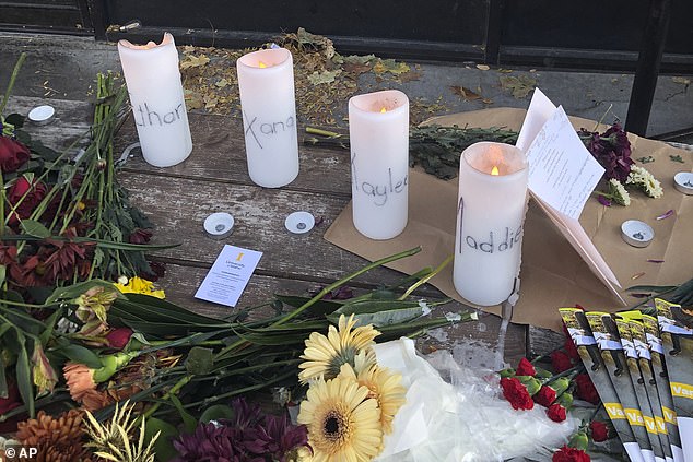 A table outside the restaurant had four white candles, one for each of the victims.