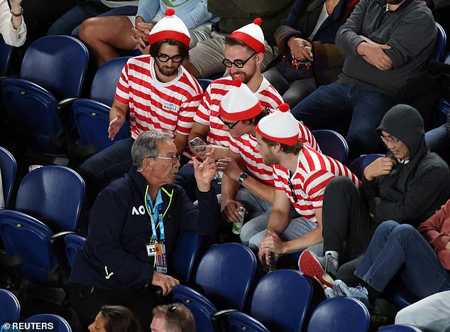 A group of rowdy fans dressed as Where's Wally?  they receive a safety briefing at Novak Djokovic's match on Thursday night before being thrown off the pitch.