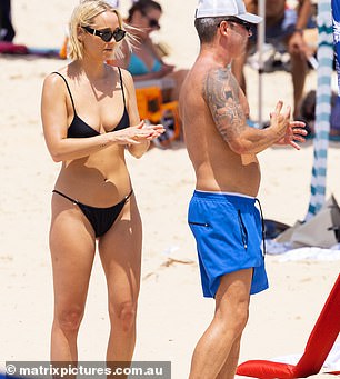 Jade Yarbrough applies sunscreen to Michael Clarke on the beach in Noosa on January 7.