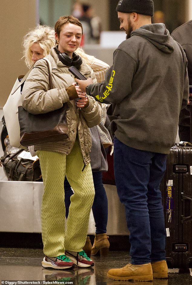 Comfort: He donned a spotted green shirt and a pair of sweatpants in a zig-zag pattern while appearing to have a conversation with someone at baggage claim.