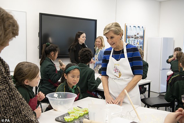 Sophie (pictured wearing a personalized apron) making cupcakes with students from Connaught Junior School in Bagshot