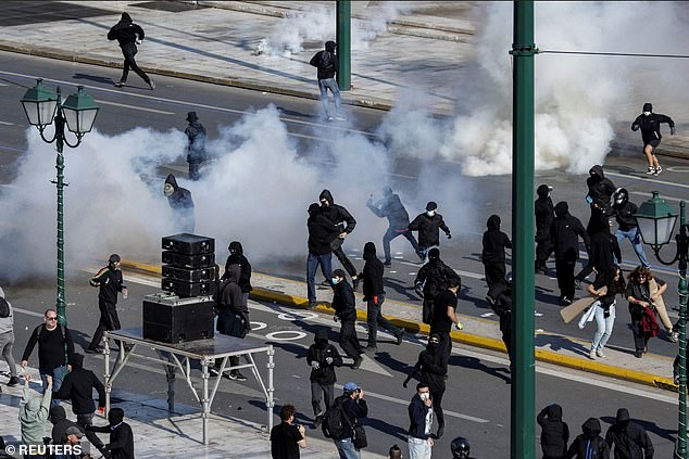 GREECE: Protesters flee from tear gas as they clash with riot police, during a demonstration marking a 24-hour general strike, in Athens, Greece, November 9, 2022