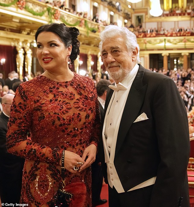 Anna Netrebko accessorized her stunning dress with a red and black clutch on her wrist, dangling ruby ​​earrings and a statement ring.