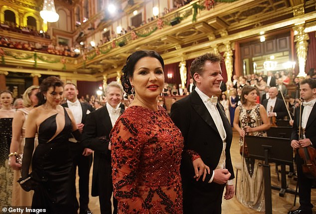 Anna Netrebko (pictured) stole the show in a dazzling floor-length ruby ​​red gown amidst a monochrome sea.