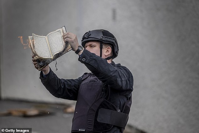 Rasmus Paludan pictured burning a Koran during an election meeting in Stockholm, May 2022