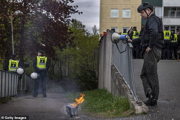 Paludan burning a Koran during an election meeting in Husby, Stockholm, in May 2022