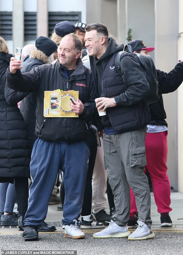 Beaming: Kai Widdrington (right) also stopped for a chat with fans waiting in the cold.