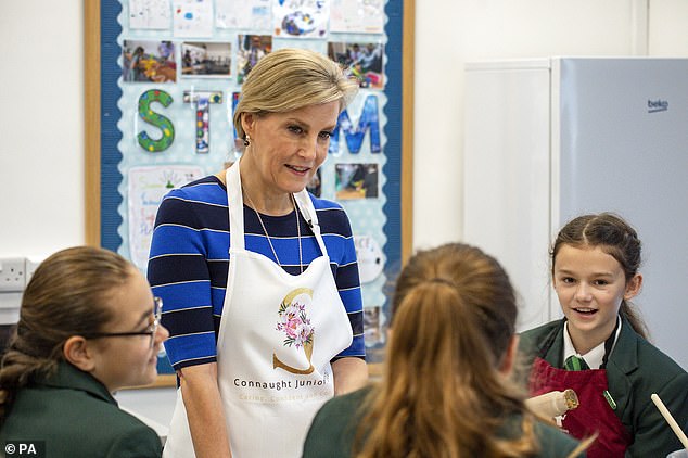 Sophie donned a blue striped dress and received a personalized apron yesterday at Connaught Junior School in Bagshot.