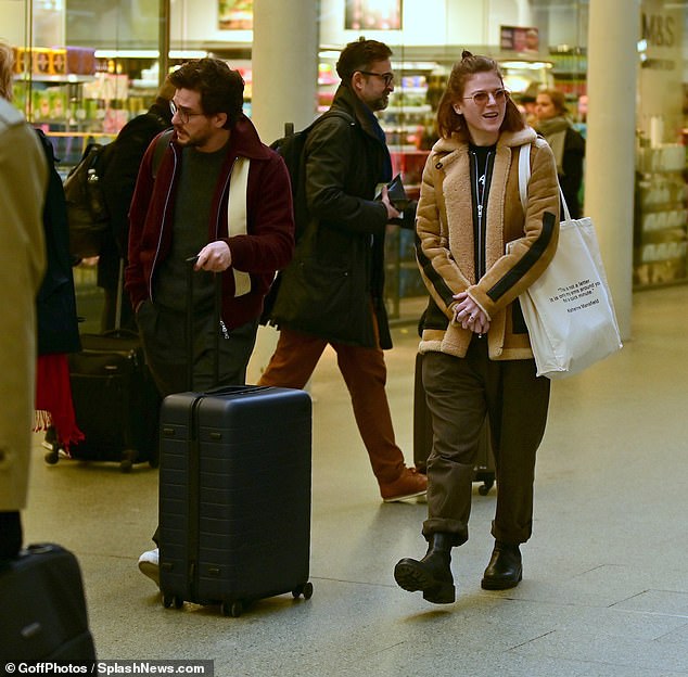 Here we are: Kit wore round glasses as she steered a blue suitcase through the busy train station.