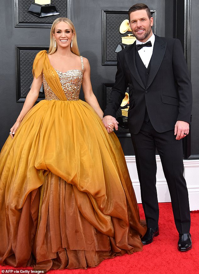 Love of her life: Underwood (left) and husband Mike Fisher arrive at the 64th Annual Grammy Awards at the MGM Grand Garden Arena in Las Vegas in April 2022