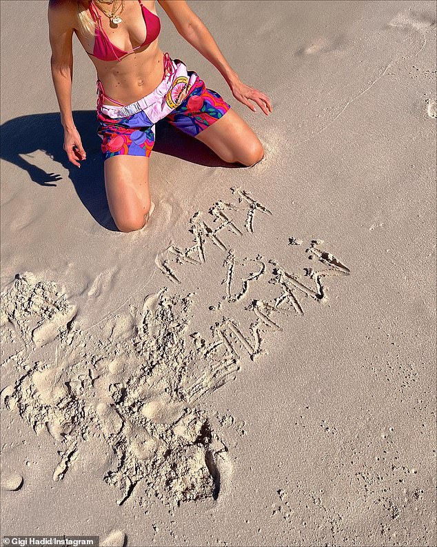 Adorable: In another image, Gigi could be seen kneeling in the sand next to 'Mama [heart] Khai, that she had written in the sand