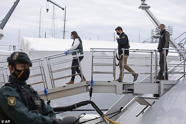 A US federal agent and two civil guards board the yacht called Tango in Palma de Mallorca, Spain, on April 4, 2022.