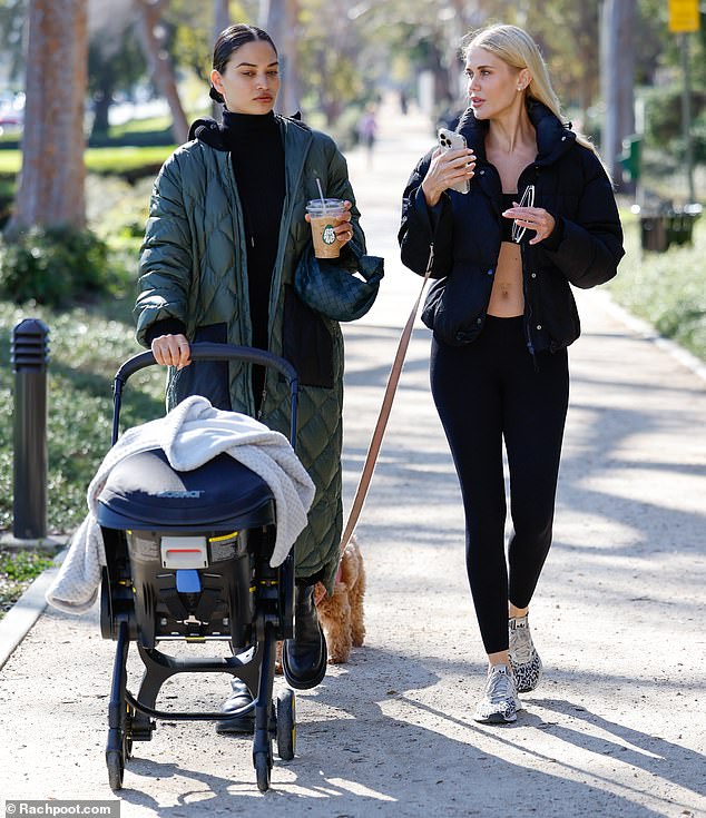 Cozy and comfortable: The Australian model dressed in a forest green coat as she pushed her son Zai in a stroller and chatted with the DJ during her outing in Beverly Hills